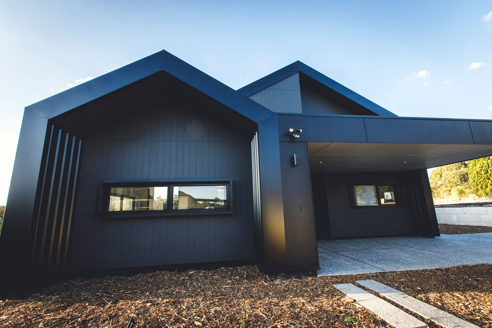 Ejemplo de fachada negra minimalista de una planta con revestimientos combinados, tejado a dos aguas y tejado de metal