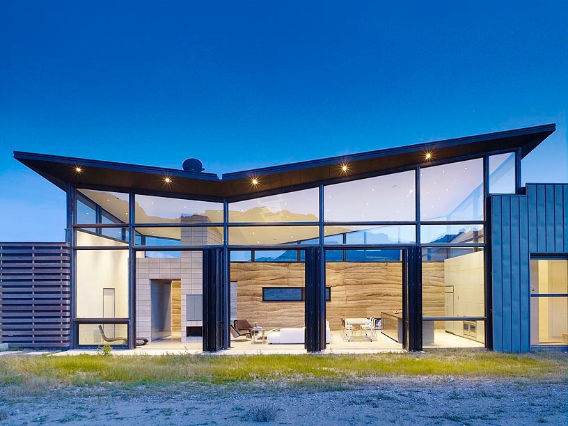 Aménagement d'une grande façade de maison marron contemporaine en verre à un étage avec un toit en appentis.