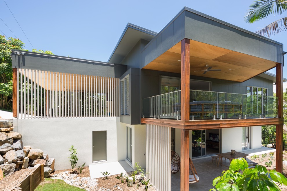 Diseño de fachada de casa gris contemporánea de tamaño medio de dos plantas con revestimiento de aglomerado de cemento, tejado plano y tejado de metal