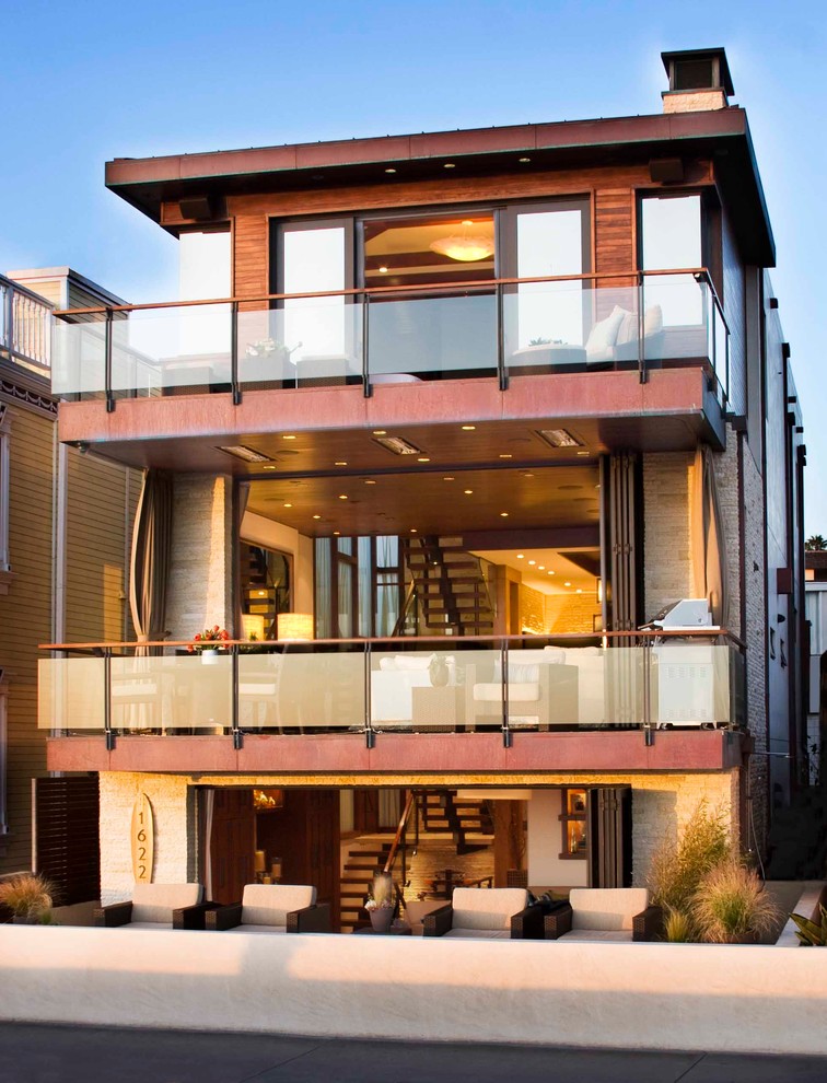 Foto på ett funkis flerfärgat hus, med tre eller fler plan, platt tak och tak i mixade material
