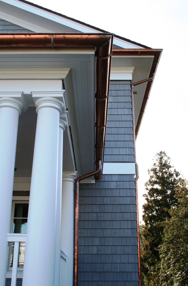 Réalisation d'une grande façade de maison grise tradition à deux étages et plus avec un revêtement en vinyle, un toit à deux pans et un toit en shingle.