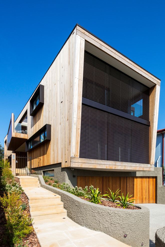 Photo of a beige contemporary two floor house exterior in Sydney with wood cladding and a flat roof.