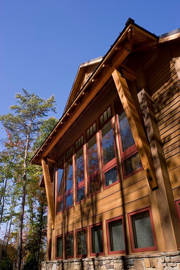 Modelo de fachada de casa marrón rústica grande de dos plantas con revestimiento de madera, tejado a dos aguas y tejado de metal