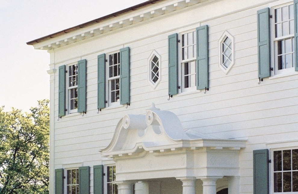 Immagine della facciata di una casa grande bianca classica a tre piani con rivestimento in legno