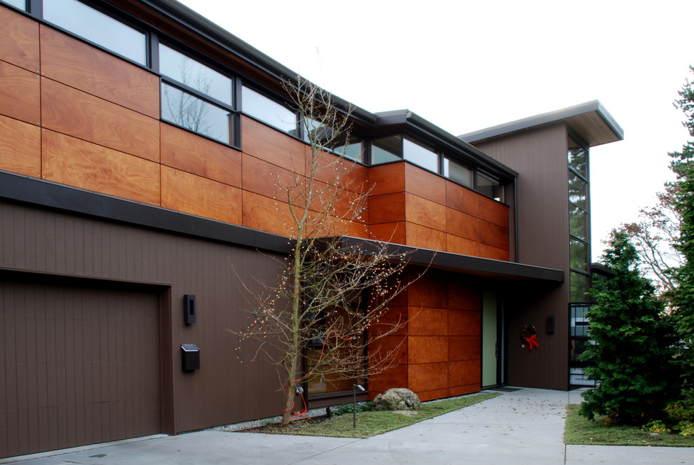 На фото: двухэтажный, деревянный, коричневый дом в современном стиле с односкатной крышей