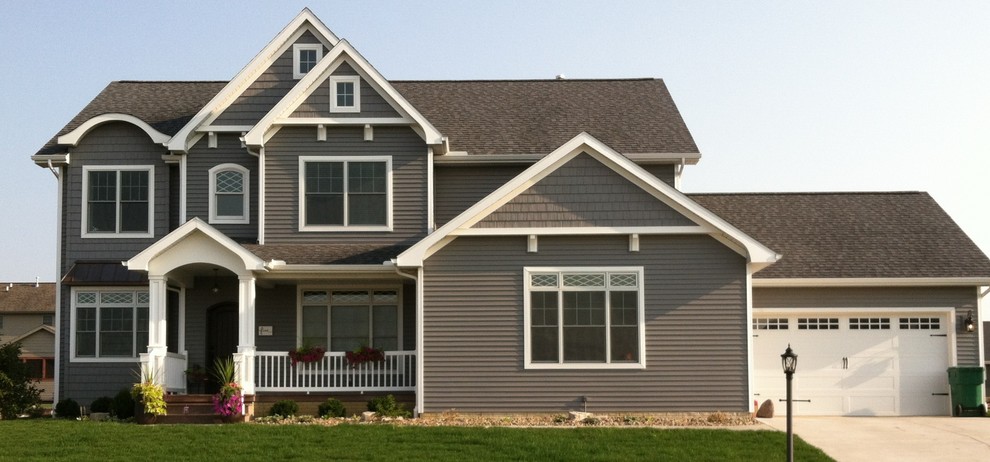 Exemple d'une grande façade de maison marron chic en panneau de béton fibré à un étage avec un toit à deux pans et un toit en tuile.