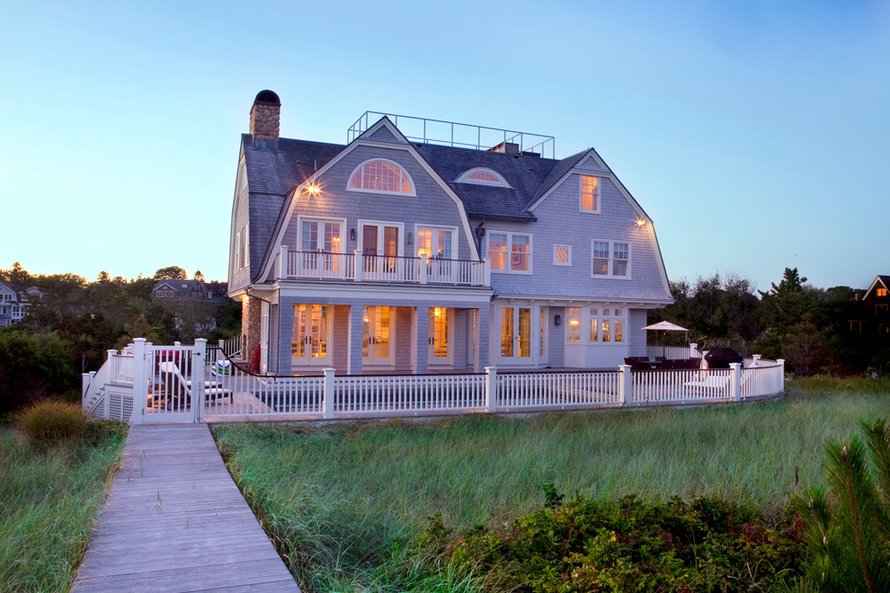 Inspiration for a large coastal house exterior in Providence with three floors, a mansard roof and stone cladding.