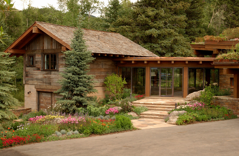 Design ideas for a rustic house exterior in Denver with wood cladding.