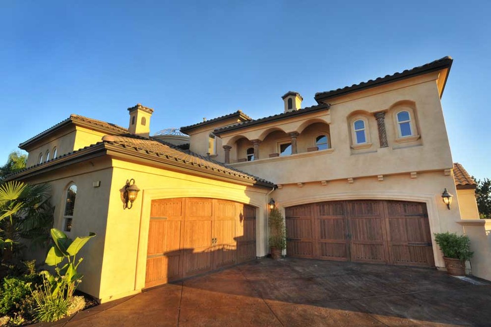 Large mediterranean beige two-story stucco house exterior idea in Sacramento with a hip roof and a tile roof