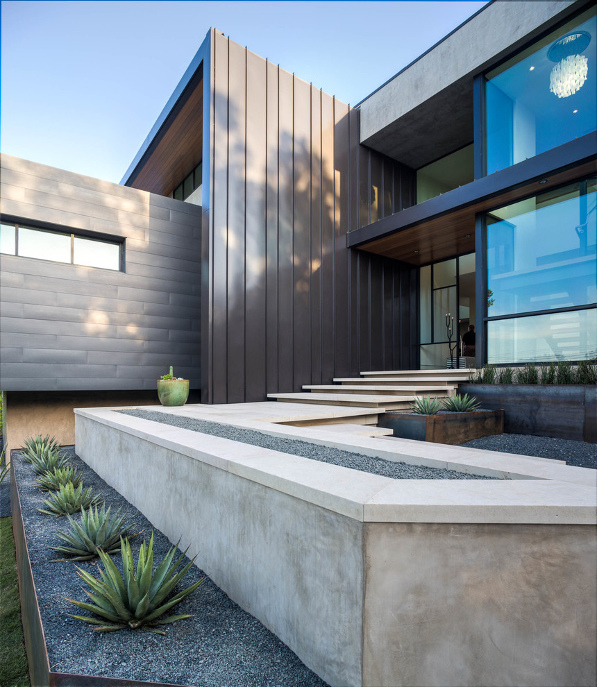 Стильный дизайн: двухэтажный, большой, серый дом в современном стиле с облицовкой из металла и плоской крышей - последний тренд