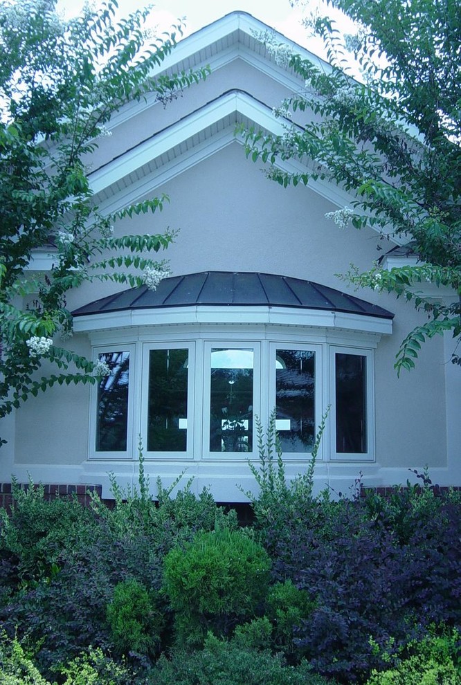 Diseño de fachada de casa multicolor clásica grande de dos plantas con tejado a dos aguas, tejado de teja de madera y revestimiento de estuco