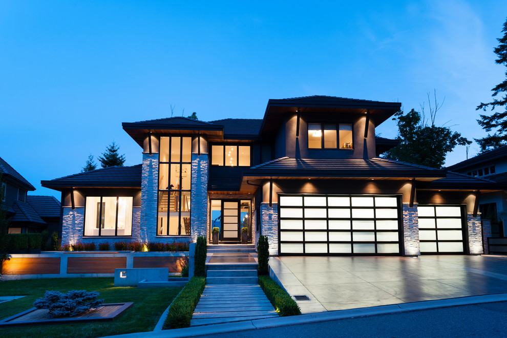 This is an example of a medium sized and gey contemporary detached house in Vancouver with three floors, mixed cladding, a half-hip roof and a tiled roof.