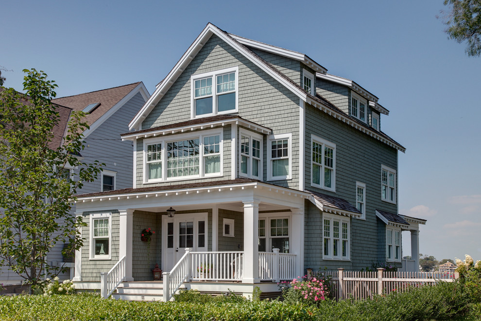 Idée de décoration pour une façade de maison grise tradition en bois.