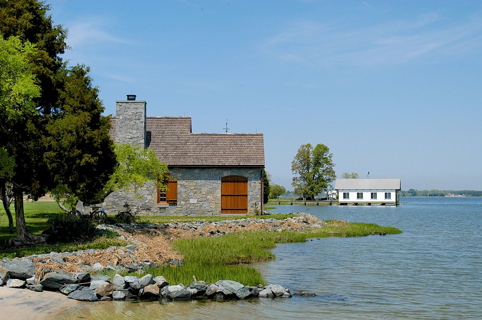 Immagine della facciata di una casa ampia country a un piano con rivestimento in pietra