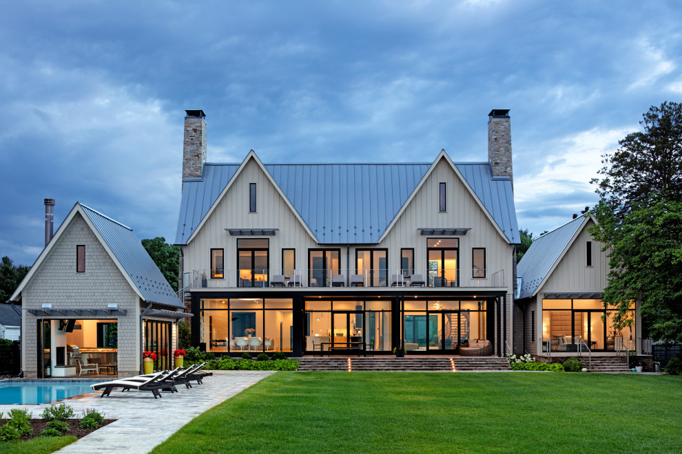 На фото: огромный, трехэтажный, белый частный загородный дом в стиле модернизм с металлической крышей