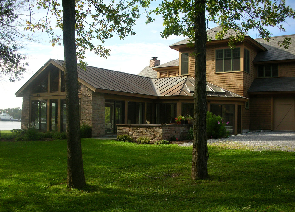 Exemple d'une façade de maison beige chic en bois de taille moyenne et à un étage.