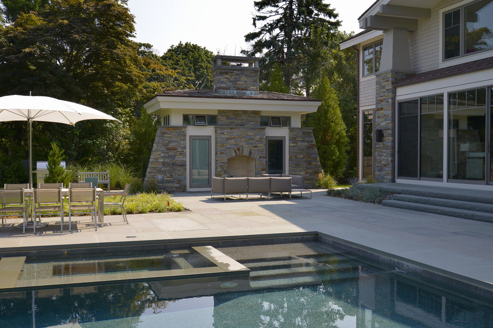 Large and beige contemporary house exterior in New York with three floors, stone cladding and a pitched roof.