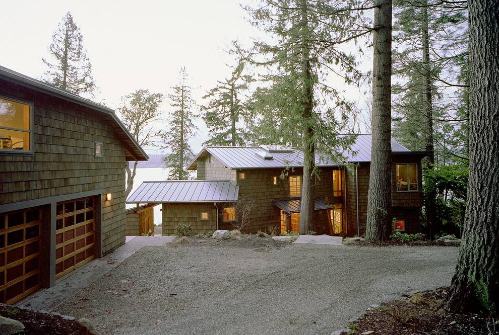 Réalisation d'une grande façade de maison grise chalet à un étage avec un revêtement en vinyle et un toit à deux pans.
