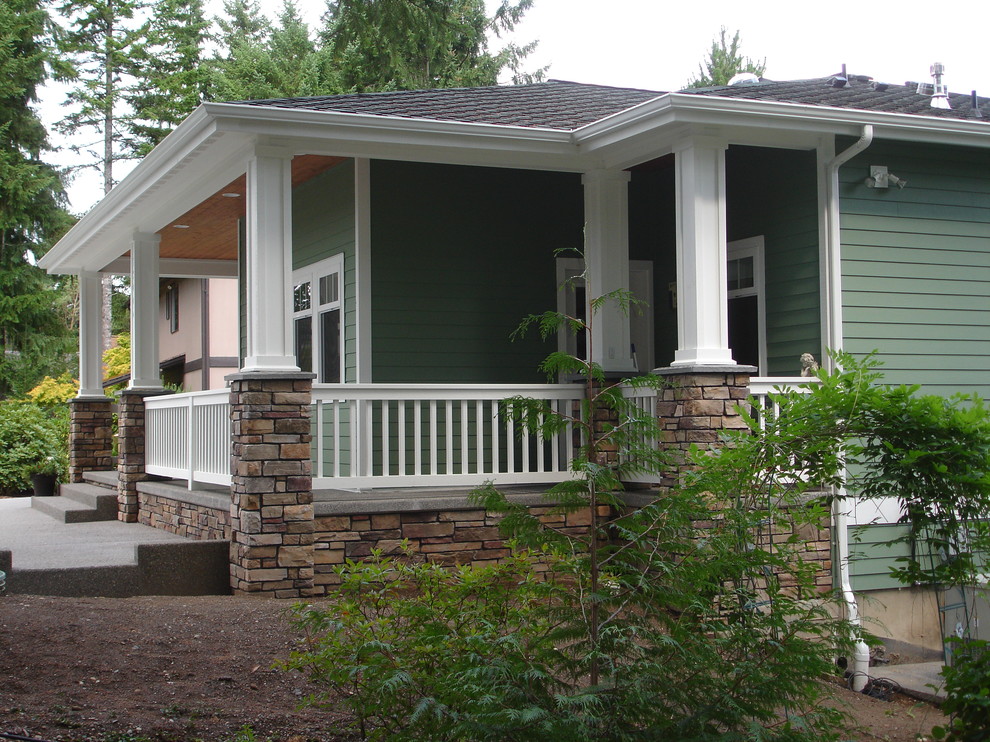 Imagen de fachada de casa verde de estilo americano de tamaño medio de dos plantas con revestimiento de aglomerado de cemento, tejado a dos aguas y tejado de teja de madera