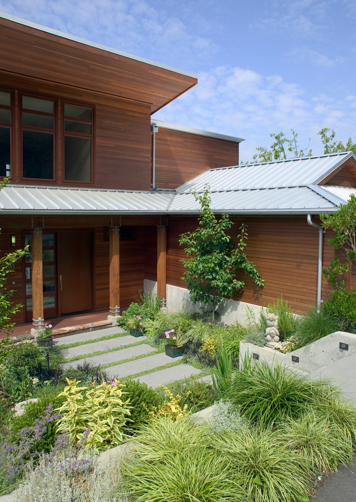 Modelo de fachada actual de dos plantas con revestimiento de madera y tejado a dos aguas