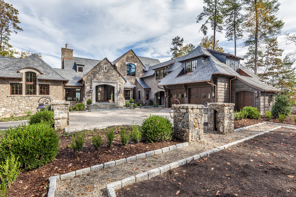 Example of a huge mountain style brown two-story stone exterior home design in Other with a shingle roof