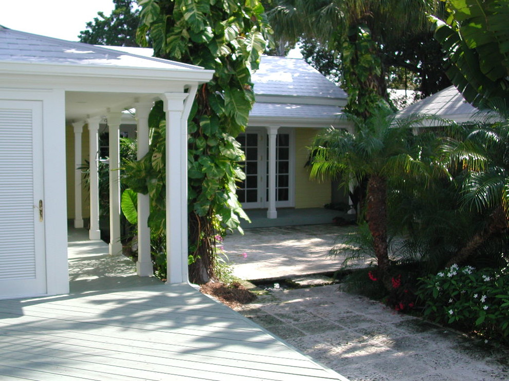 Design ideas for an expansive and yellow bungalow house exterior in Miami with wood cladding.