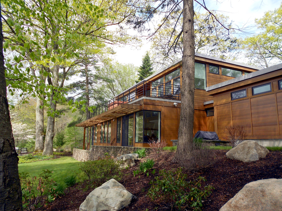 Réalisation d'une façade de maison marron design en bois de taille moyenne et à un étage.
