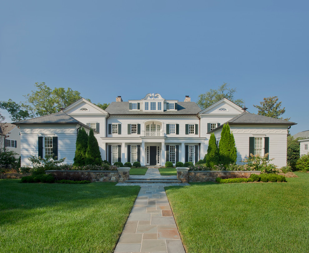 Immagine della facciata di una casa ampia bianca classica a tre piani