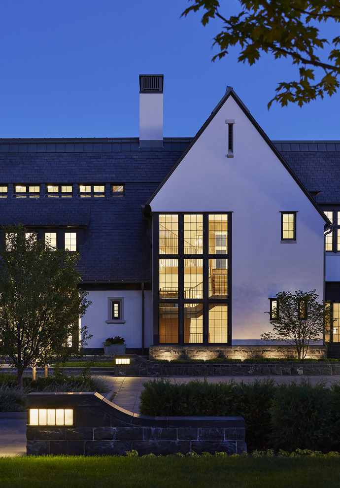 На фото: огромный, белый, трехэтажный частный загородный дом в стиле неоклассика (современная классика) с комбинированной облицовкой и крышей из смешанных материалов