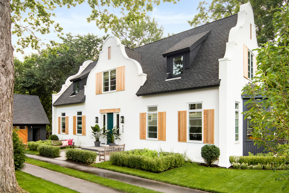 На фото: двухэтажный, белый частный загородный дом в стиле фьюжн с облицовкой из цементной штукатурки, двускатной крышей и крышей из гибкой черепицы с