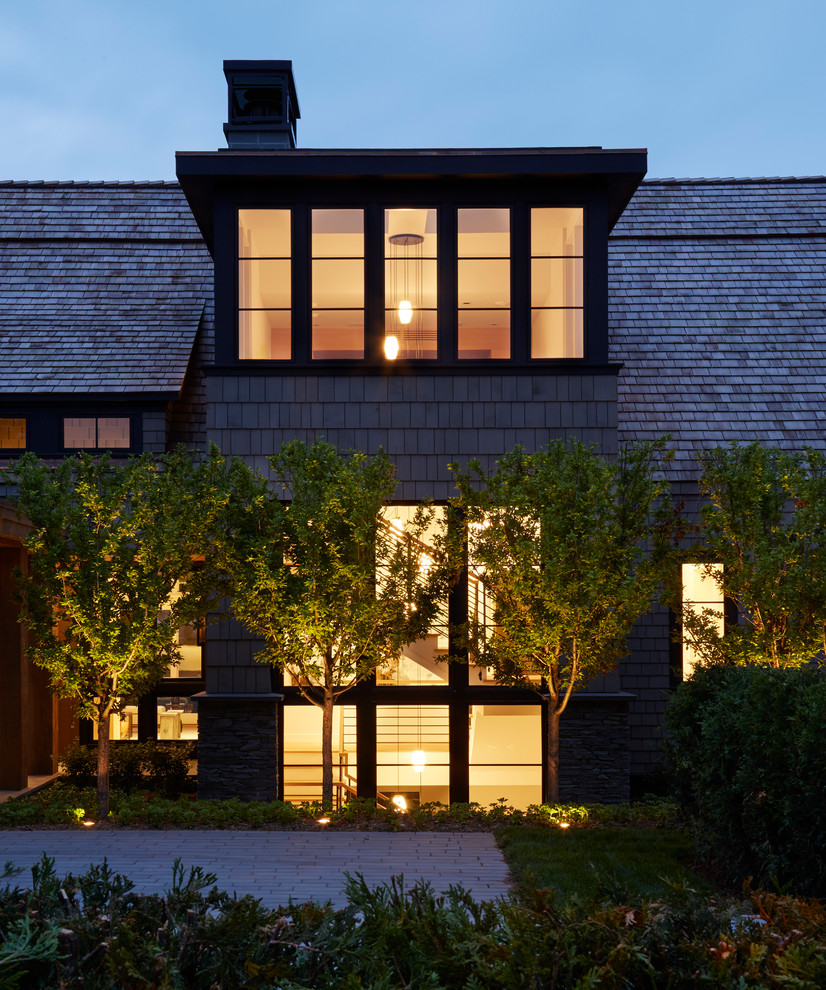 Cette image montre une façade de maison grise minimaliste de plain-pied avec un revêtement mixte.
