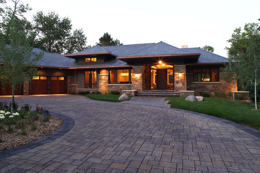 Стильный дизайн: большой, двухэтажный дом в восточном стиле с облицовкой из камня и вальмовой крышей - последний тренд