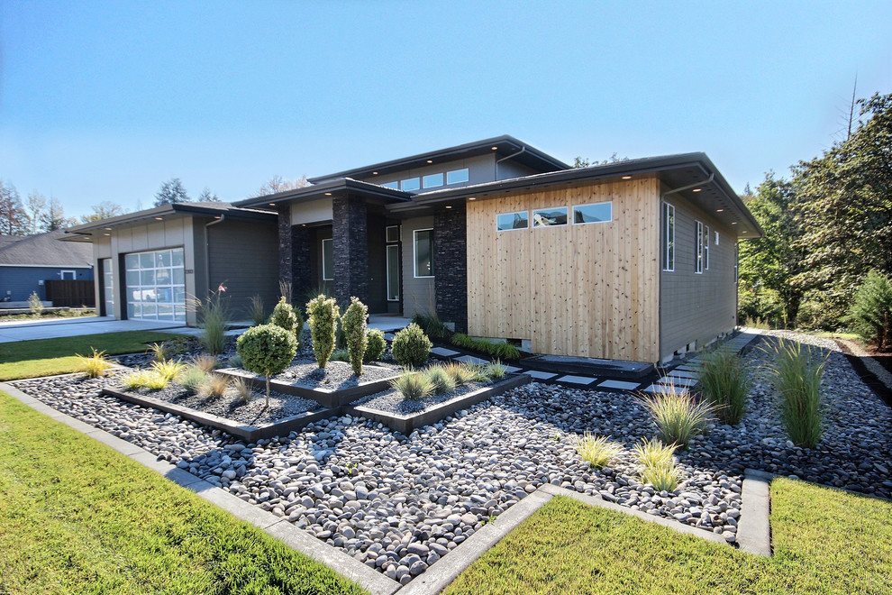 Diseño de fachada de casa gris moderna grande de una planta con revestimientos combinados, tejado a dos aguas y tejado de teja de madera