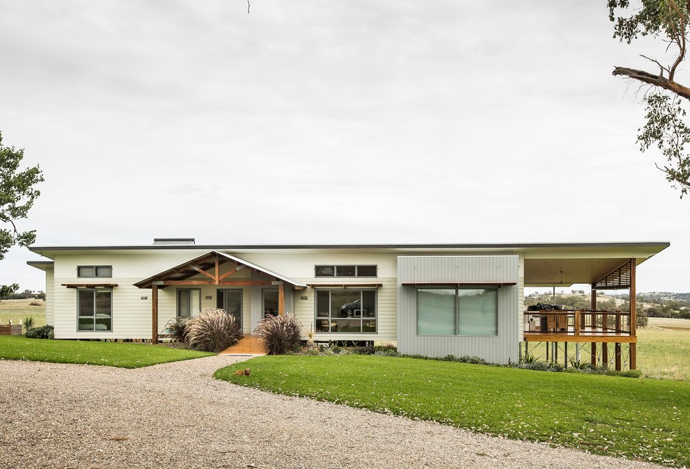 Идея дизайна: одноэтажный, бежевый частный загородный дом среднего размера в современном стиле с комбинированной облицовкой и металлической крышей