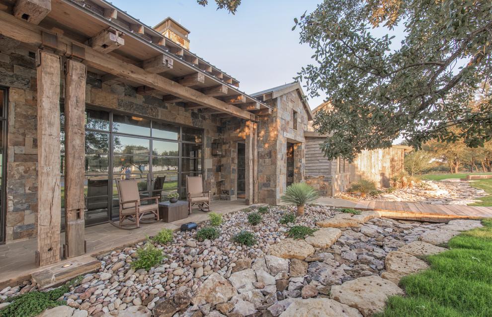 Photo of a rustic bungalow detached house in Dallas with stone cladding.