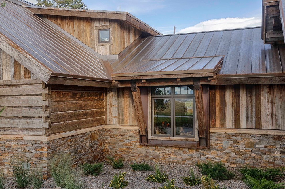 Ejemplo de fachada de casa marrón rural con revestimientos combinados y tejado de metal