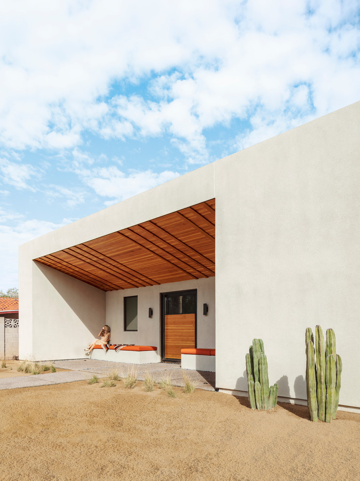 Diseño de fachada blanca de estilo americano de una planta con revestimiento de estuco y tejado plano