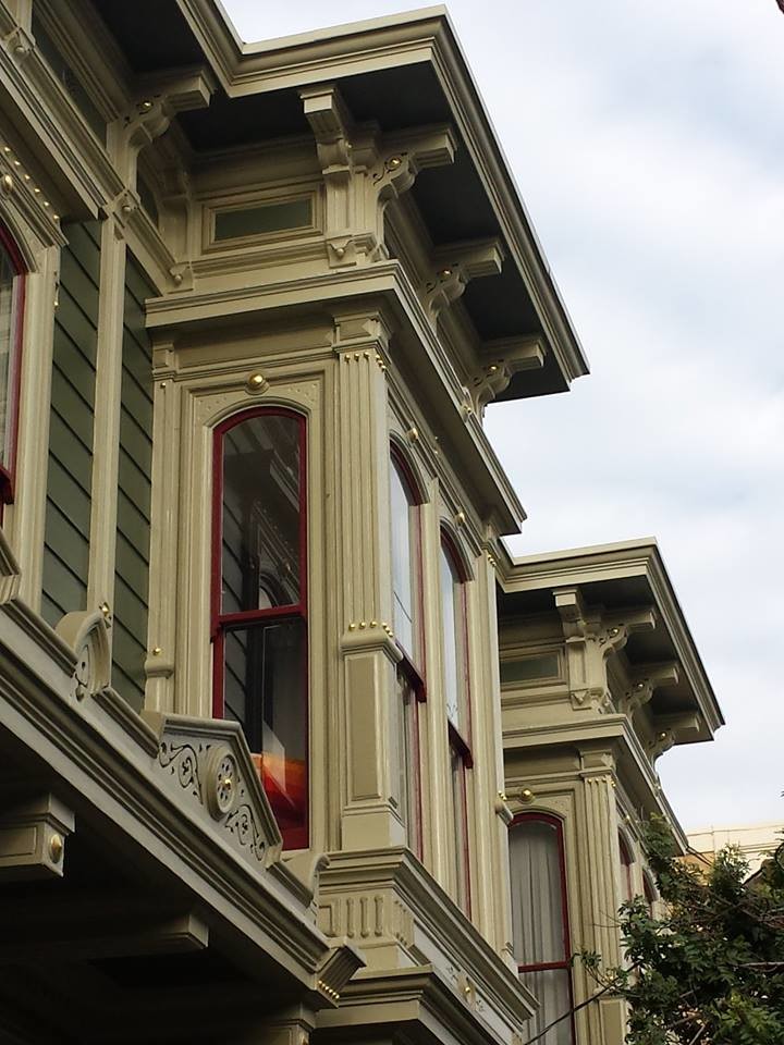 Immagine della facciata di una casa grande verde vittoriana a due piani con rivestimento in legno