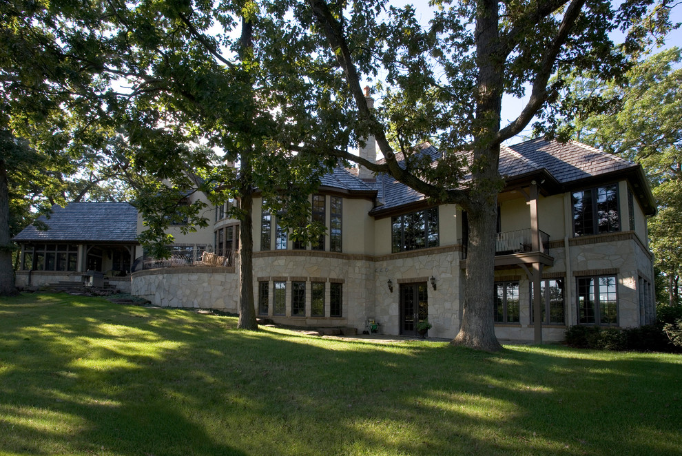 Ispirazione per la facciata di una casa ampia beige classica a due piani con rivestimento in pietra e tetto a padiglione