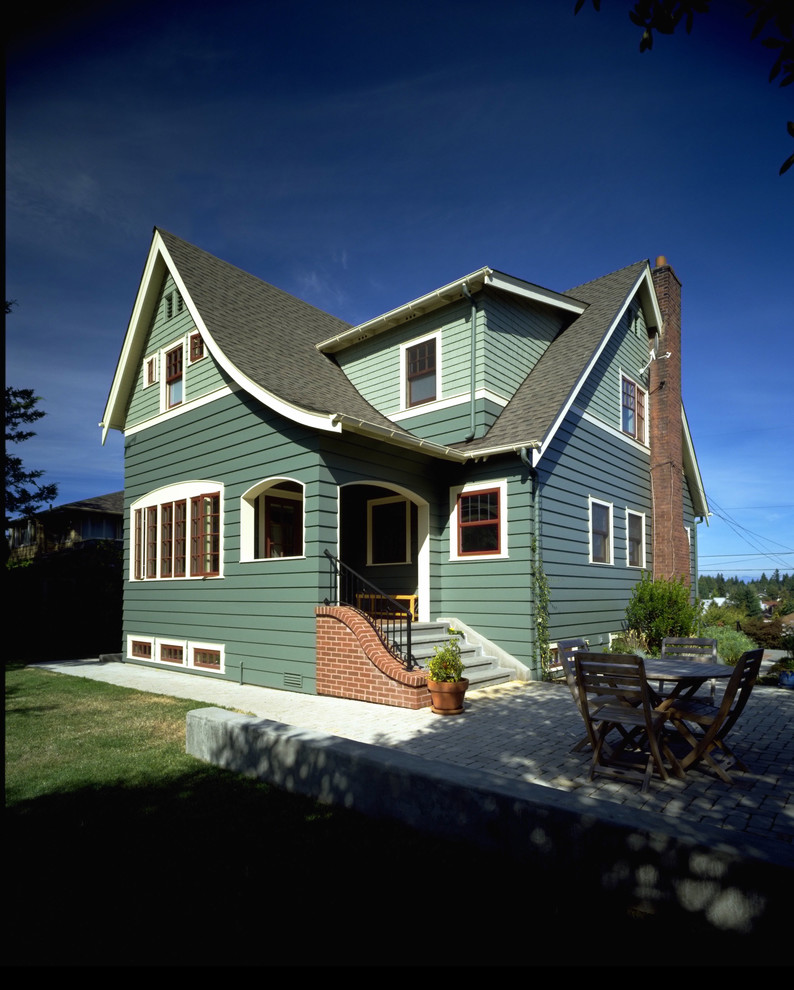 Foto della facciata di una casa verde classica a due piani di medie dimensioni con rivestimento in legno e tetto a capanna