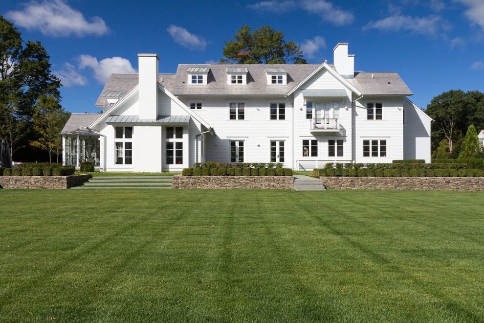 Пример оригинального дизайна: огромный, трехэтажный, белый дом в классическом стиле