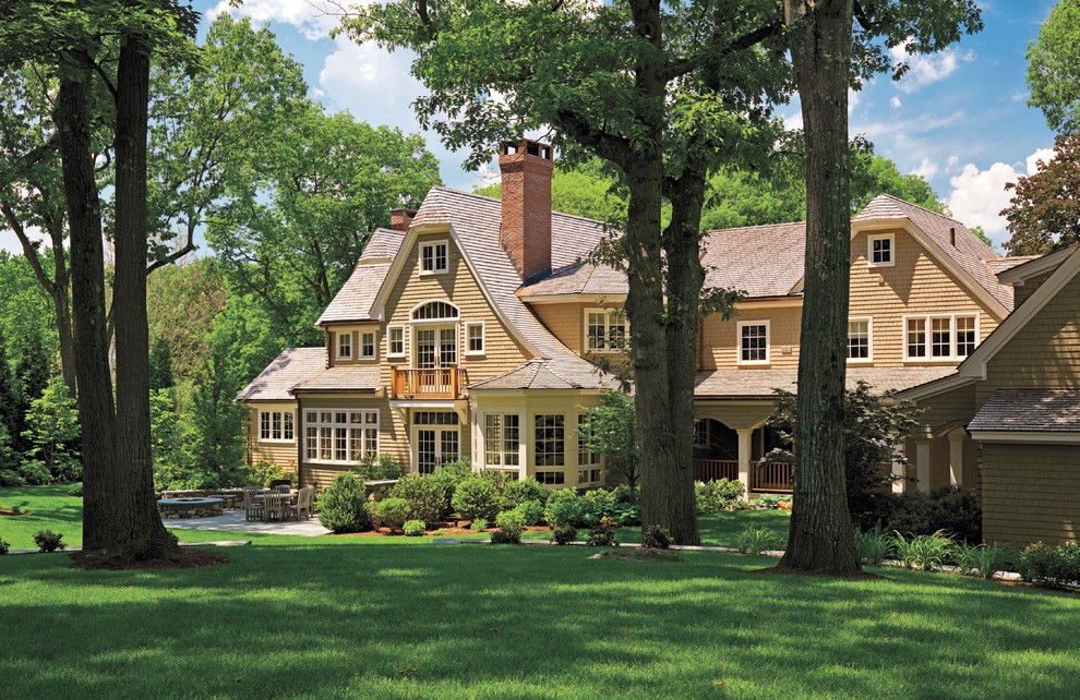 Réalisation d'une façade de maison beige victorienne en bois à un étage et de taille moyenne avec un toit à croupette et un toit en shingle.