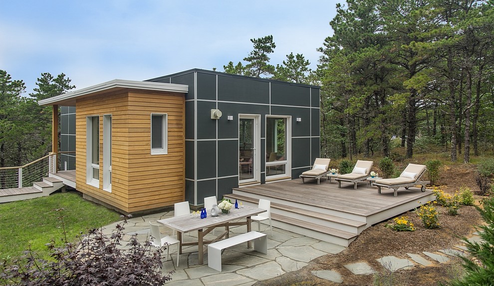 На фото: маленький, двухэтажный, черный частный загородный дом в стиле модернизм с облицовкой из ЦСП и плоской крышей для на участке и в саду