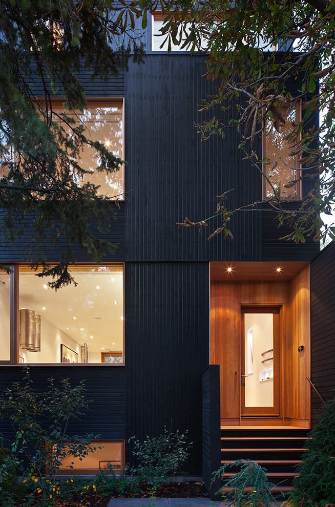 Design ideas for a medium sized and black modern house exterior in Toronto with three floors and wood cladding.
