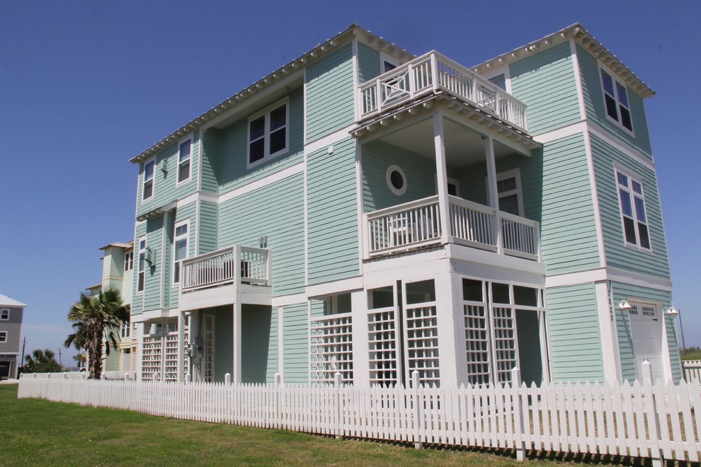 Photo of a large and blue nautical house exterior in Houston with three floors, concrete fibreboard cladding and a mansard roof.
