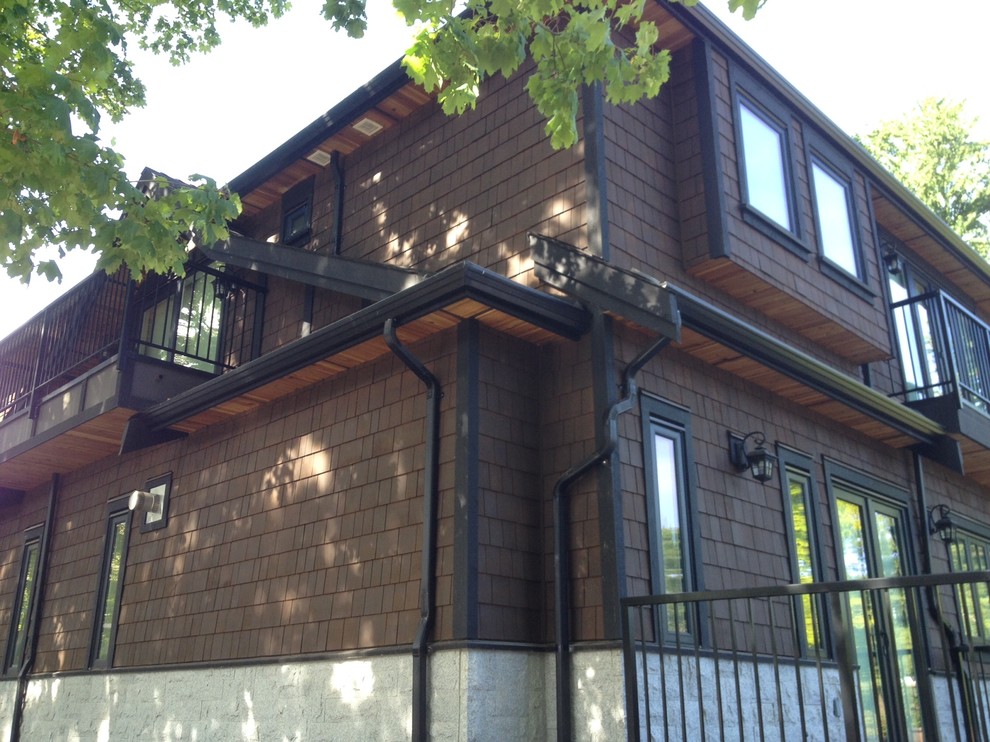 Foto de fachada marrón de estilo americano grande de tres plantas con revestimiento de madera