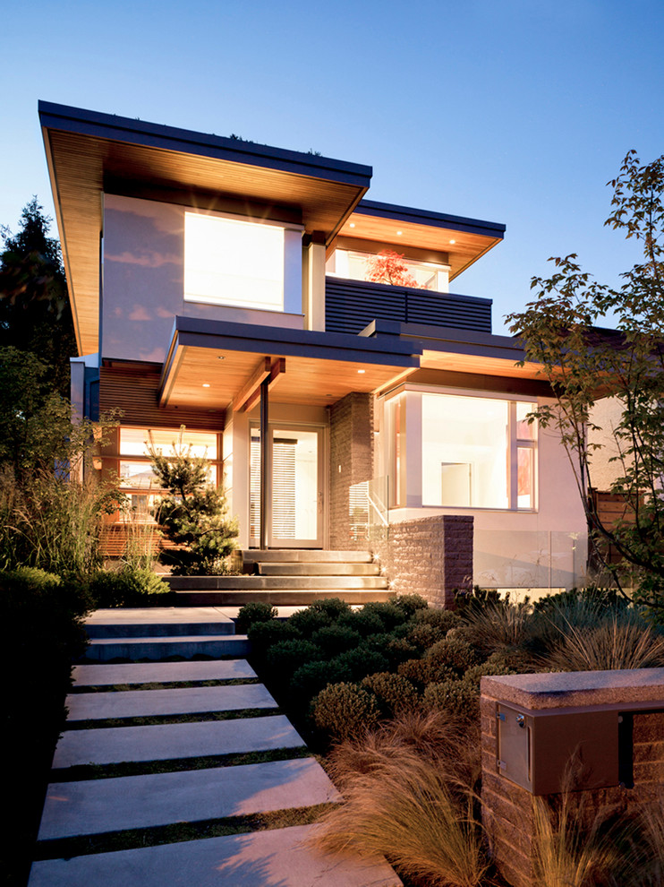 Medium sized and gey contemporary house exterior in Vancouver with three floors, mixed cladding and a flat roof.