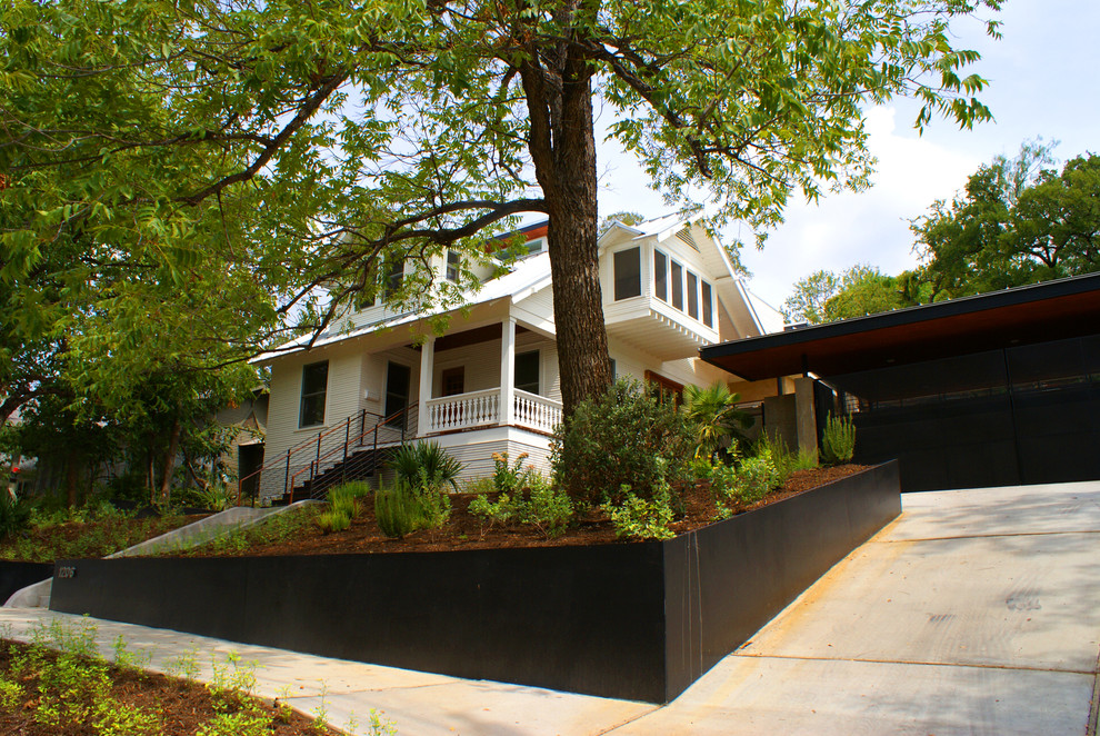 This is an example of a medium sized classic two floor house exterior in Austin with wood cladding.