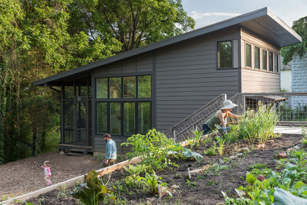 Kleines, Zweistöckiges Modernes Haus mit grauer Fassadenfarbe, Flachdach und Blechdach in Charlotte
