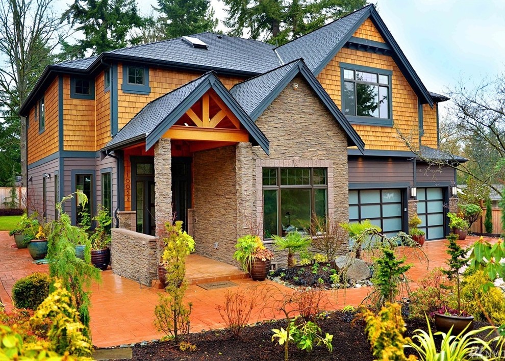 На фото: двухэтажный, разноцветный частный загородный дом в стиле кантри с комбинированной облицовкой и вальмовой крышей